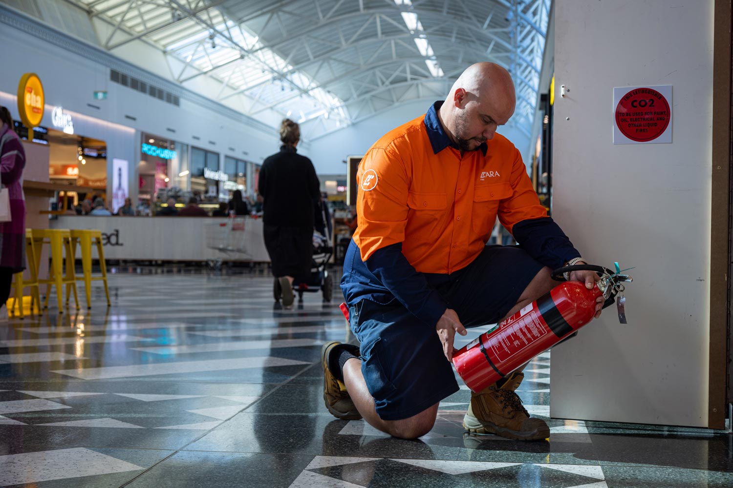 ARA Fire extinguishers and fire blankets displayed against a neutral background, emphasizing the company's fire safety equipment offerings. The extinguishers are arranged in a row alongside folded fire blankets.